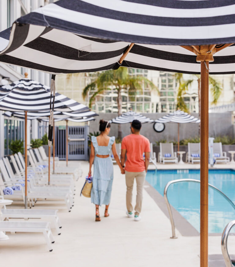 A couple walking beside the Carté Hotel pool